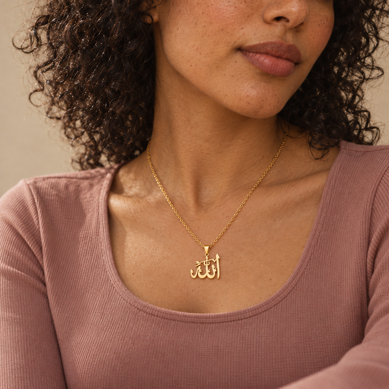 Gold Jalal pendant necklace worn over a dusty pink ribbed top