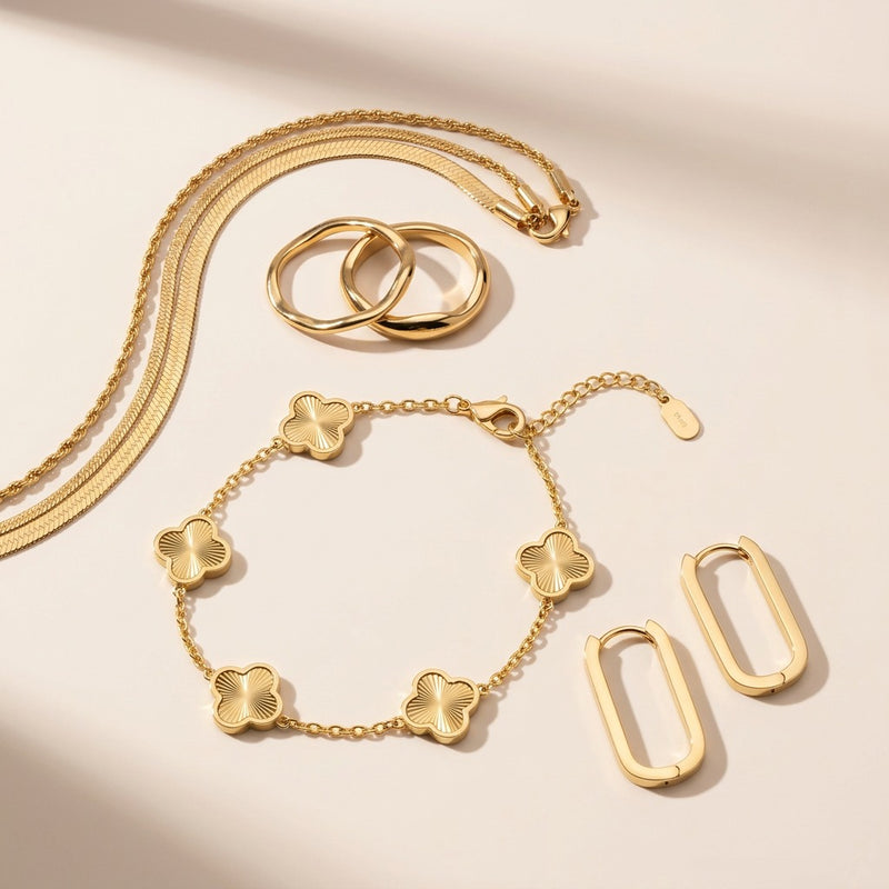 The Noor Gold Essentials - four 18K gold plated pieces: layered chain, square hoops, unity ring and clover bracelet