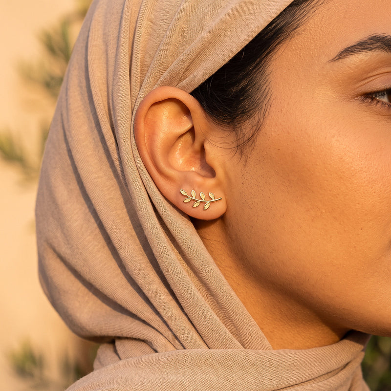 Gold olive branch ear climber worn with a hijab
