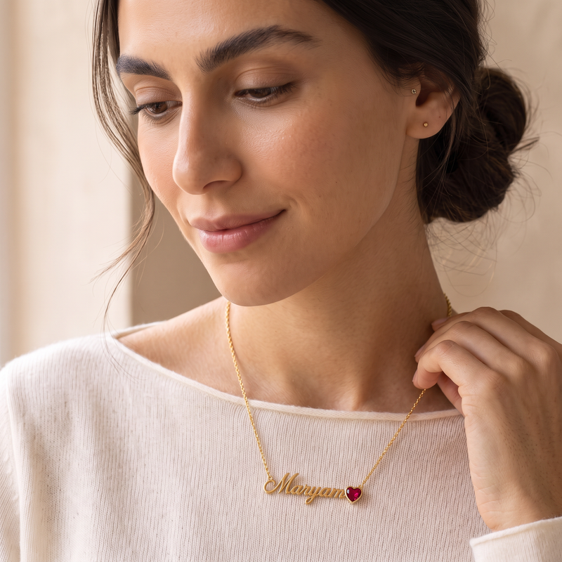 Name necklace with heart-cut birthstone, close detail