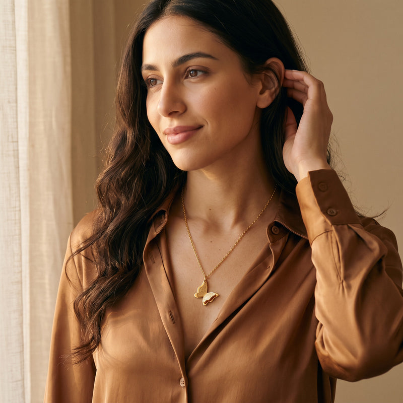 Woman wearing the gold Farasha butterfly necklace