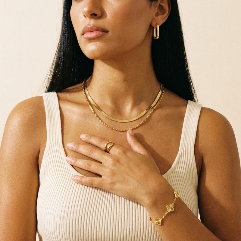 The Noor Gold Essentials worn - layered chain, square hoop, unity ring and clover bracelet