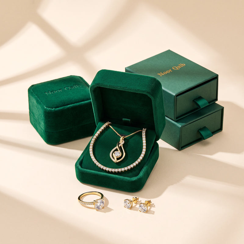 The Noor Moissanite Set gift-ready - pendant and tennis bracelet in the Noor Qalb emerald velvet box, ring and studs beside, with the green Noor Qalb gift boxes