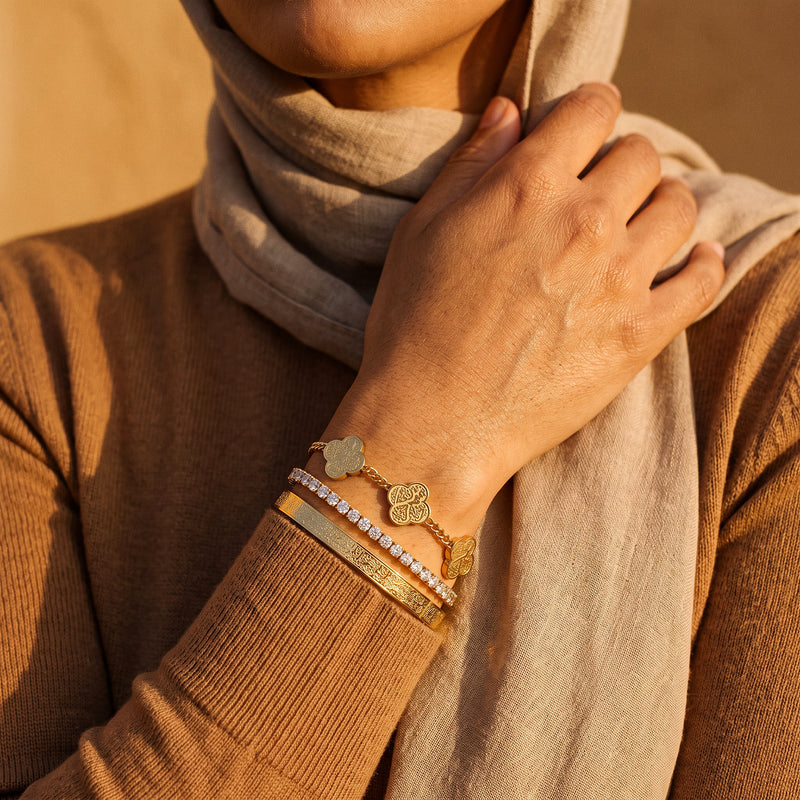 The Noor Radiance Stack worn - tennis bracelet, Ayatul Kursi cuff and clover bracelet stacked on the wrist