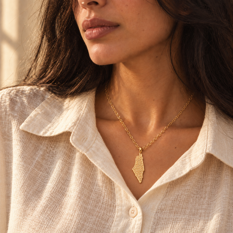 Palestine map necklace worn, gold engraved pendant on cream linen