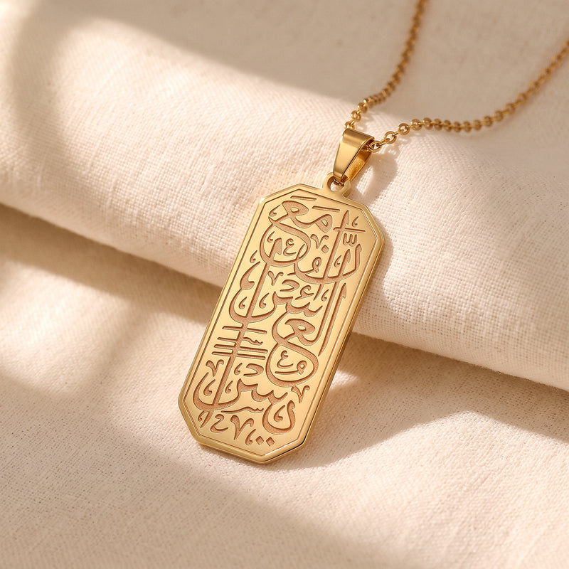 Close-up of the engraved Quran calligraphy on the gold Yusra Pendant