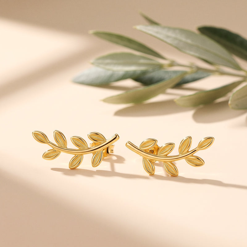 Gold olive branch ear climbers beside a sprig of olive leaves