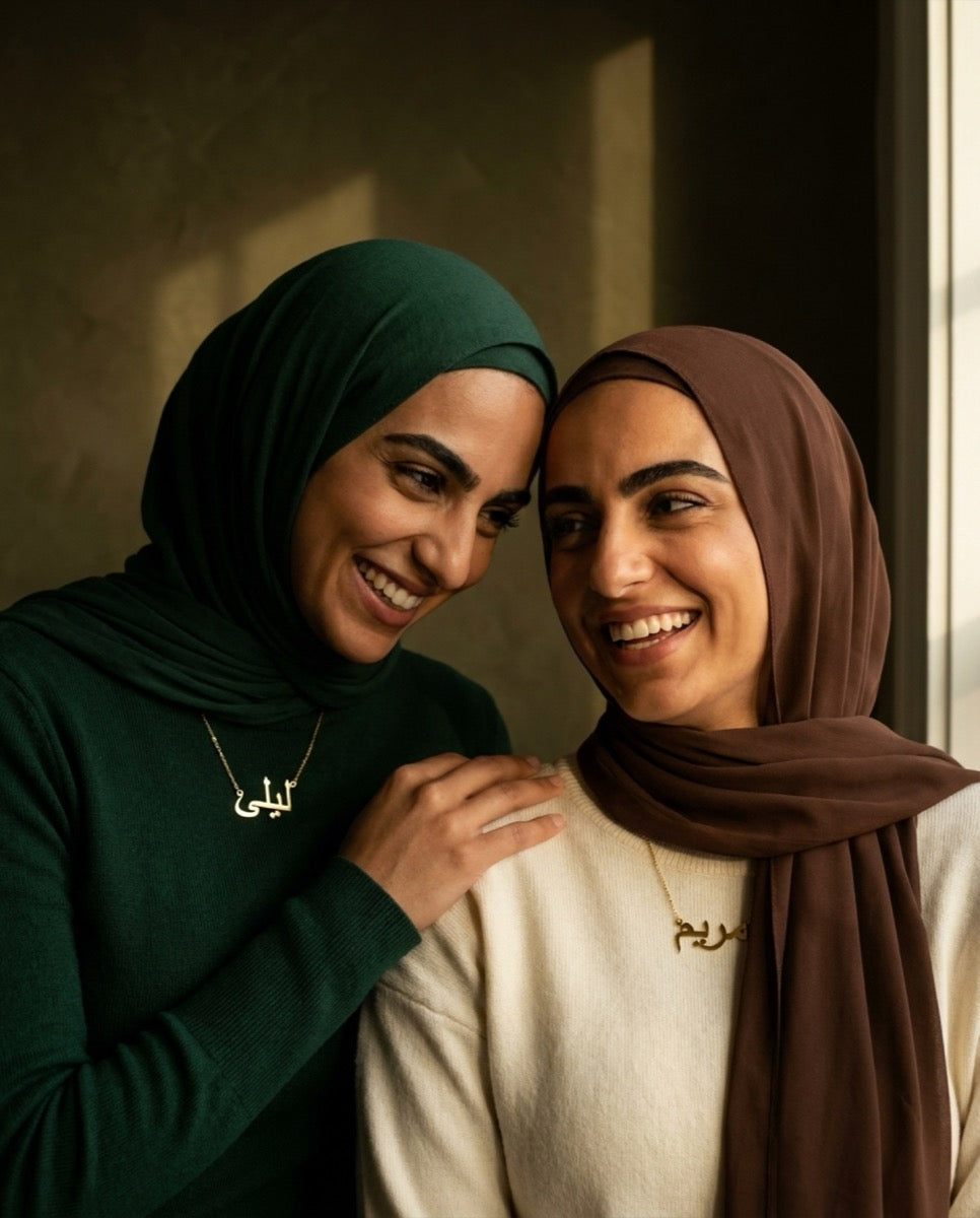 Two sisters wearing custom Arabic name jewellery